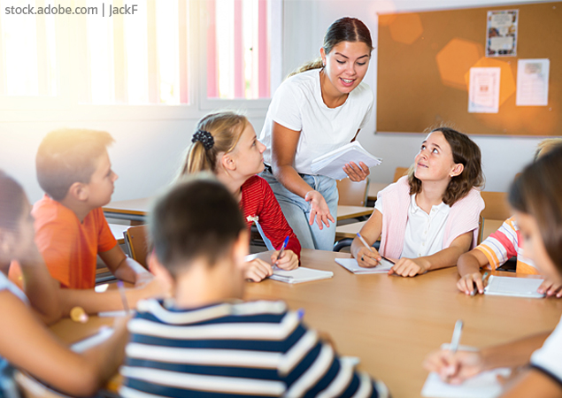 REB-Themen-Impulse-Duke-Award-Engagement Eine ältere Schülerin gibt einer Gruppe jüngerer Schüler Nachhilfeunterricht